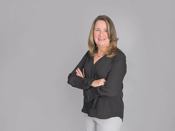 Kathy O’Brien, MKG Marketing’s Executive Assistant, in front of a gray background | MKG Marketing