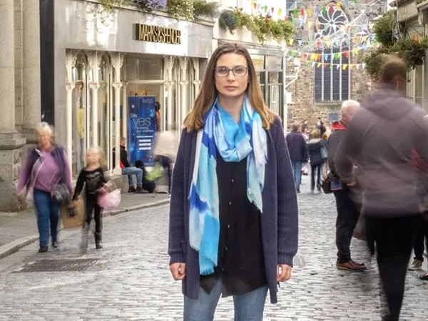 Kerry Guard, MKG Marketing’s Owner/CEO, stands on a street in Guernsey with the Town Church behind her | MKG Marketing